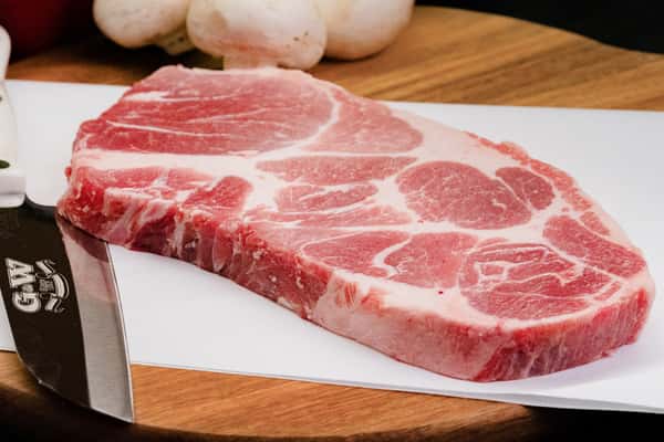 raw pork steak with marbling on cutting board ready for grilling or cooking
