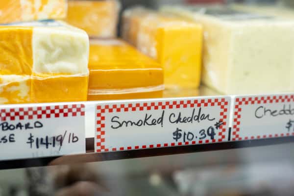 cheese blocks labeled smoked cheddar in deli case at G&W Sandwiches