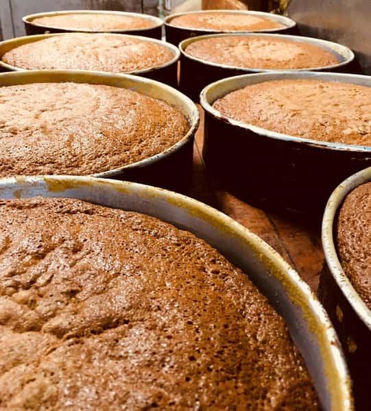 Freshly made carrot cakes in pans on wood table