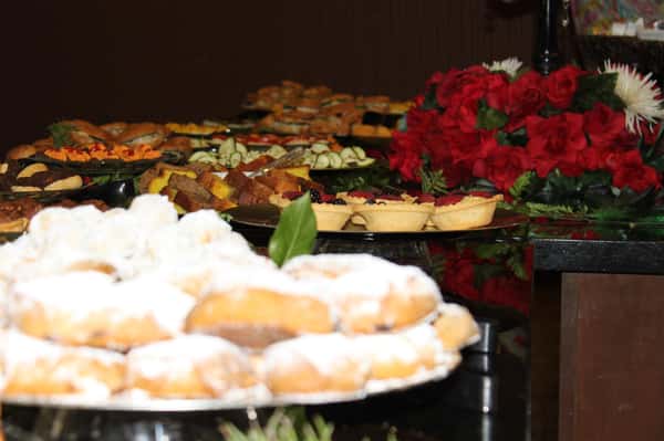trays of dessert including cinnamon rolls, mini tarts, and breads