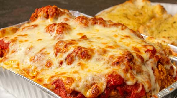 Baked ziti with pasta in rich tomato sauce, topped with melted mozzarella and baked until golden and bubbly.