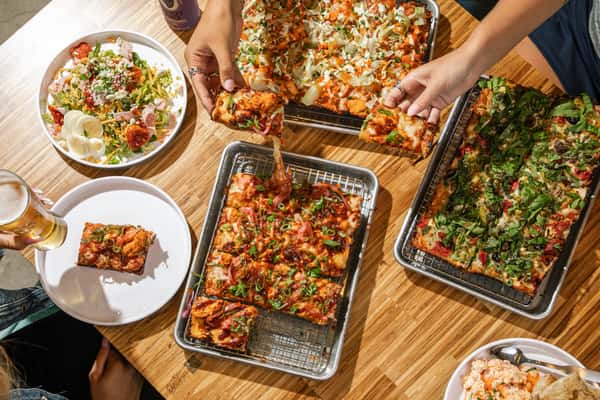 Group eating pizza and beverages at table
