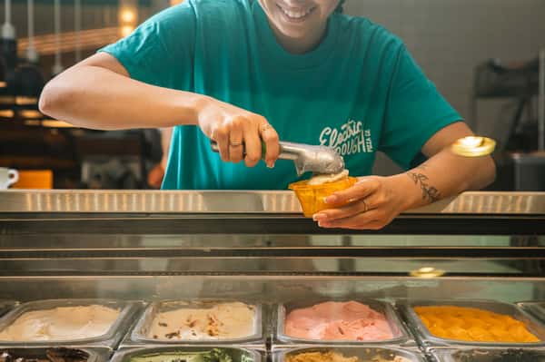 Photo of a staff person at Electric Dough Pizza Co. scooping gelato