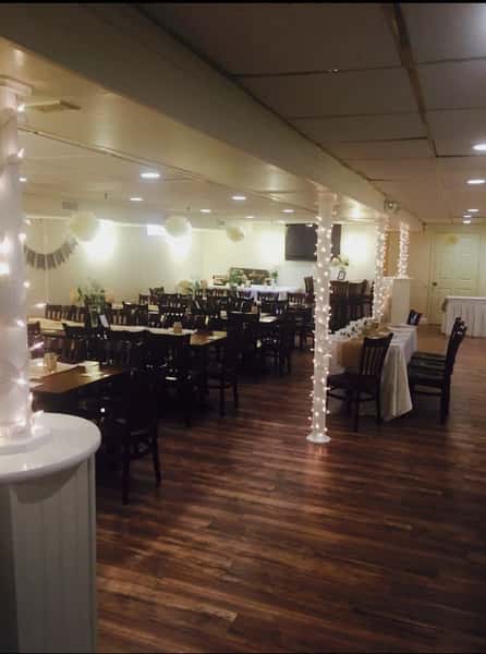 banquet room decorated for an event with string lights and paper lanterns