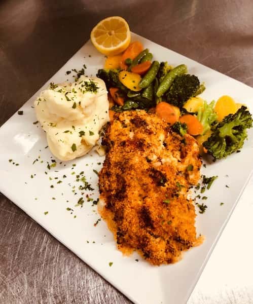 breaded fried fish with sauteed vegetables and mashed potatoes
