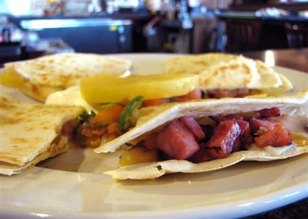 Quesadilla cut up in triangles and served with pico de gallo topped with a pineapple slice