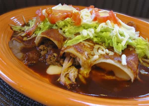 Chimichangas served win sauce and topped with shredded lettuce, tomato and cheese
