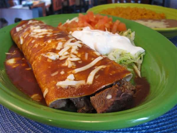 Chimichanga with green sauce served with guacamole, pico de gallo and sour cream