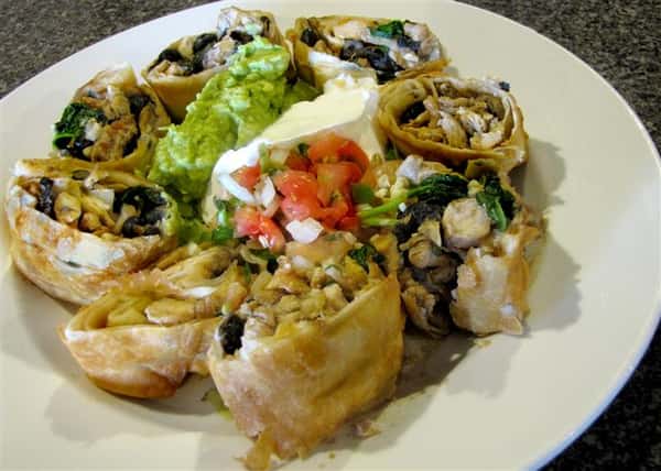 Tortilla wrapped pinwheels served with guacamole, sour cream and pico de gallo in the middle