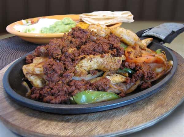 Fajita plate served with a side dish of guacamole, sour cream and pico de gallo and tortillas chips