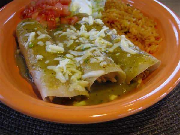 Three enchiladas served with green sauce and sides of pico de gallo, sour cream and rice