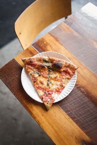 Slice of pizza on wooden table