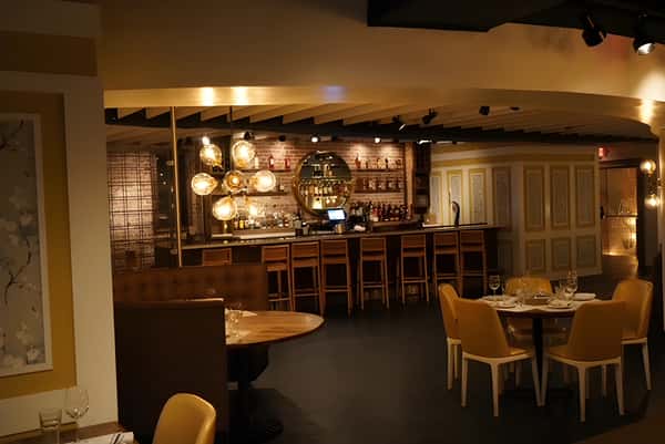 Cozy bar area with wooden bar seating and warm ambient lighting.