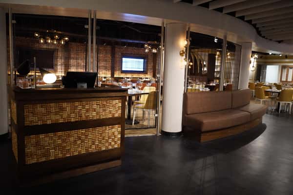 Restaurant bar with tiled front, booth seating, and open floor space.