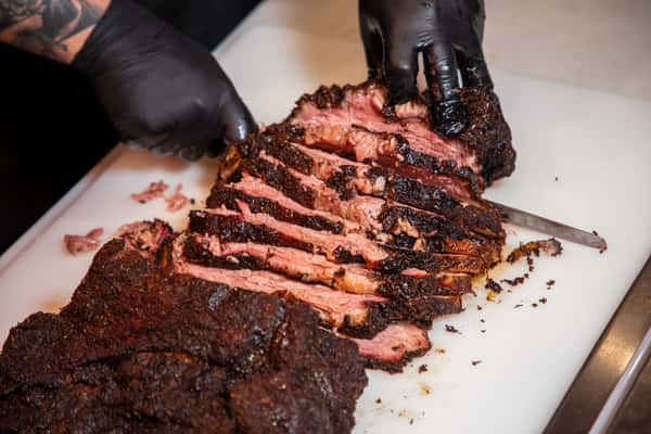Chef's hands cutting brisket