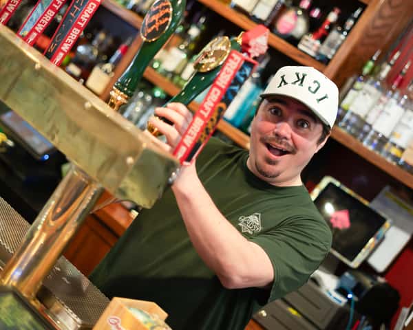 Anthony making a silly face to the camera as he pours a pint of beer.