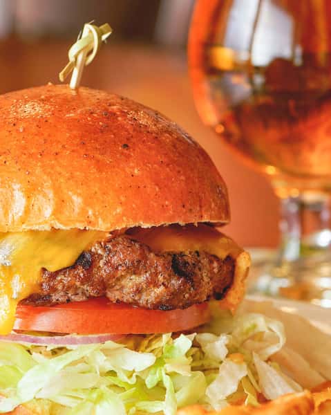 Up-close image of a basin burger next to a pint of beer.