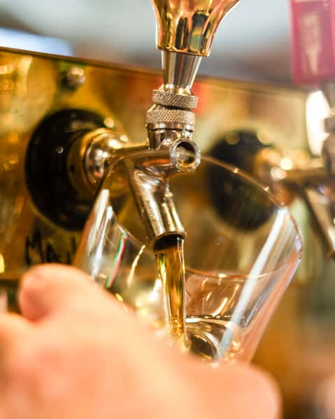 hand pouring a pint of beer.