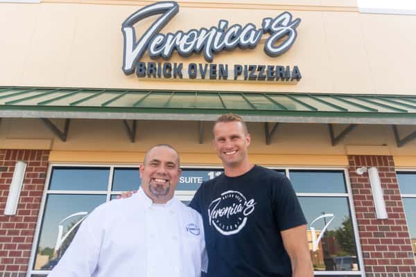 owners in front of store