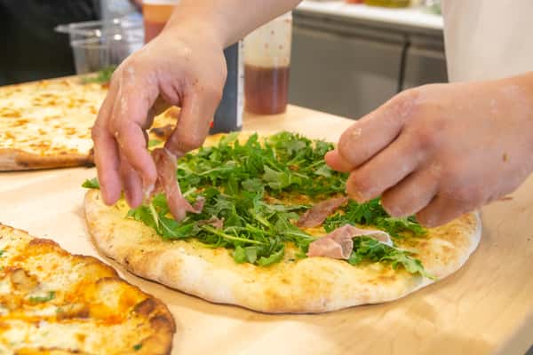 Hands preparing a pizza