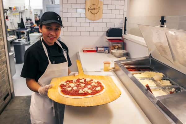 Veronica's employee holding pizza