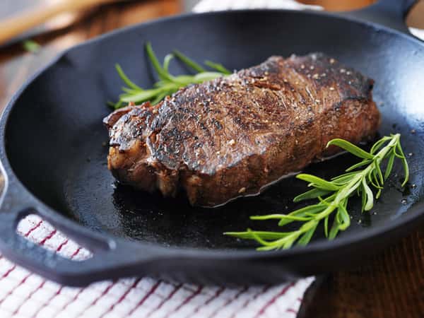 steak on a pan with rosemary