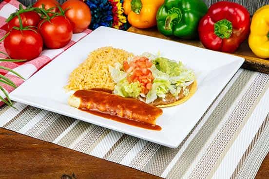 Classic Mexican combo plate featuring a cheese enchilada topped with red sauce, a crispy tostada with lettuce, tomato, and guacamole, and a side of seasoned Mexican rice.