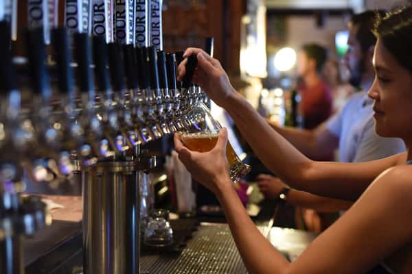 lady refilling beer on tap