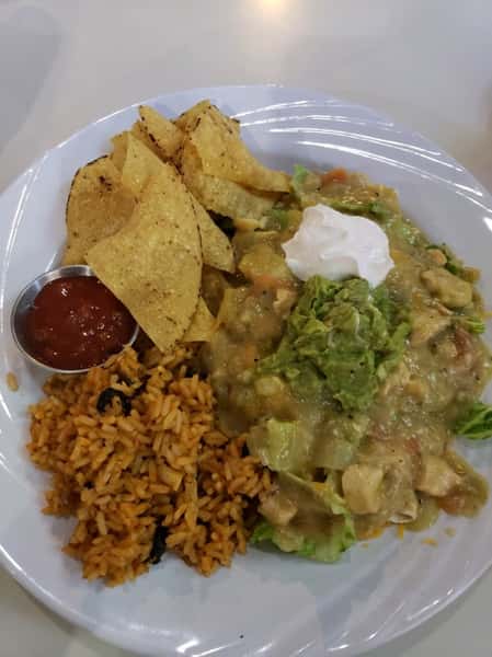 Tortilla chips with a Mexican burrito salad, including rice, guacamole, chicken, lettuce, and salsa
