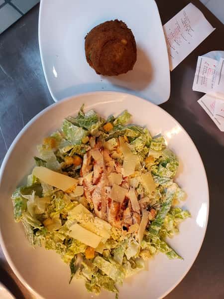 Chicken Caesar salad topped with croutons and parmesan cheese