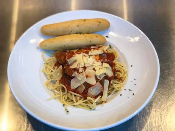 Spaghetti topped with tomato sauce, parmesan, and a side of garlic bread