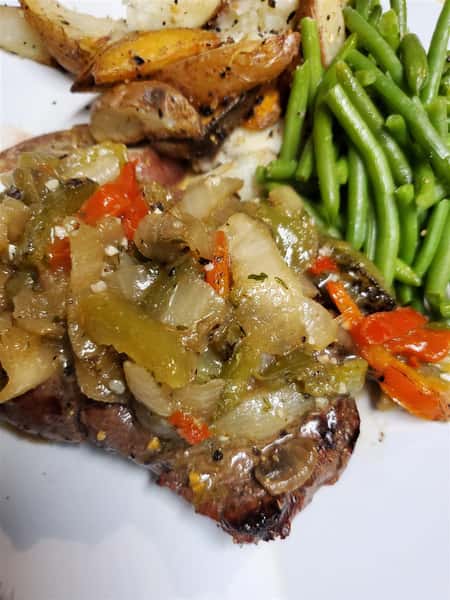 steak with peppers, onions, and side of green beas