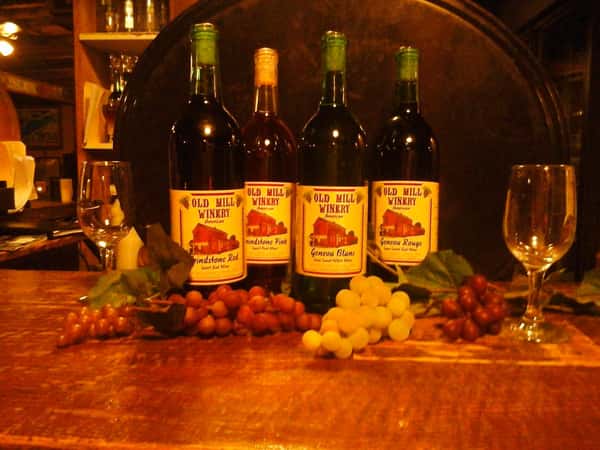 table displaying various wine bottles with grapes and wine glasses