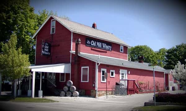 exterior of the old mill winery with wine barrels stacked together