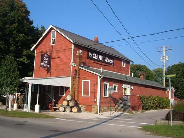 exterior of the old mill winery with wine barrels stacked together