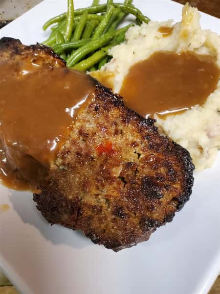 meat entree with mashed potatoes, gravy and green beans