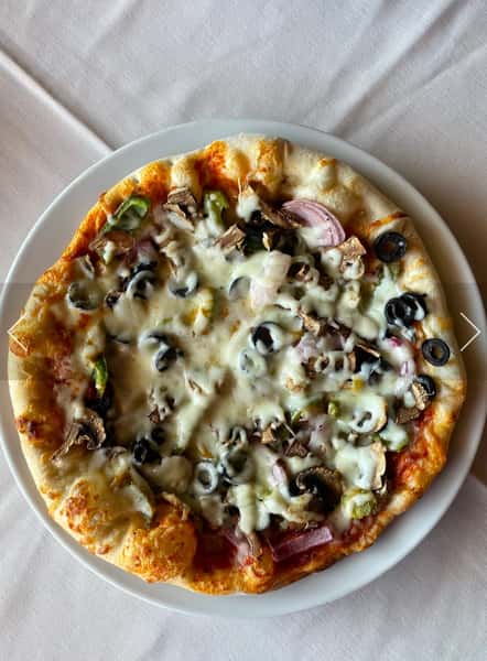 Vegetarian pizza topped with olives, mushrooms, onions, and melted cheese on a white plate