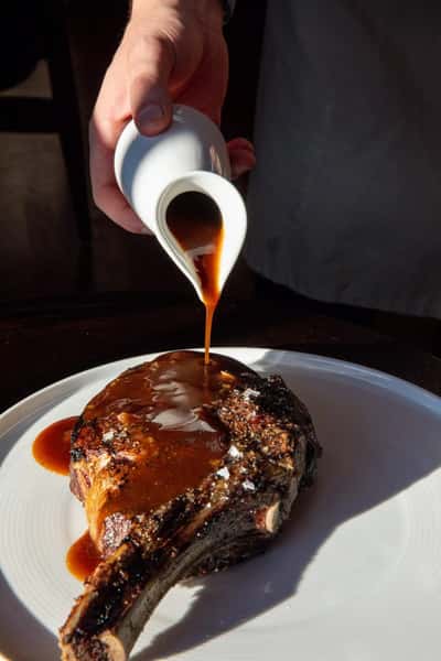 Sauce being poured onto an entree