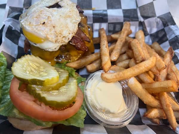 Burger with egg on it with fries