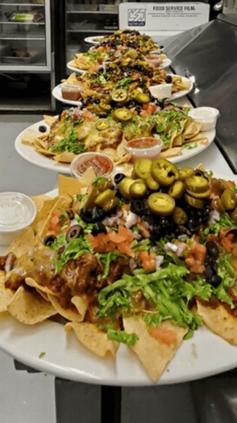 nachos with lettuce, tomato, onions, black olives, jalapenos, side of salsa, side of sour cream
