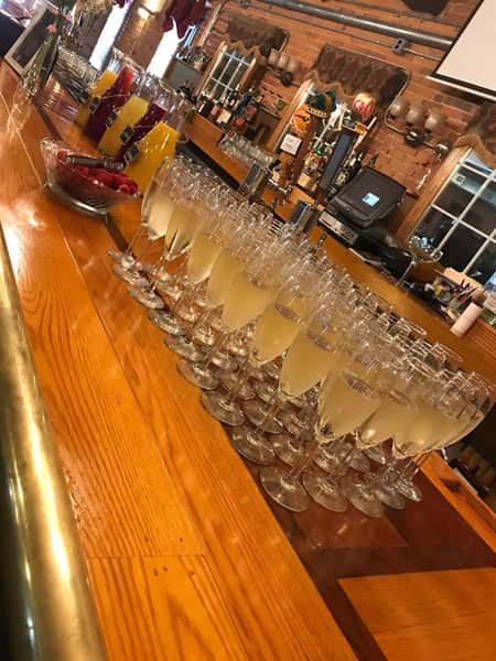 multiple filled champagne glasses on the bar