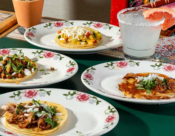 Mexican tacos and tostadas with cilantro and onions, served with a grapefruit margarita