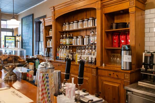 Rustic diner bar with wooden shelving, coffee station, and syrup bottles, cozy interior at One Oakland