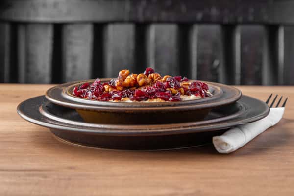 Oatmeal topped with candied pecans and dried cranberries, hearty breakfast bowl at One Oakland diner
