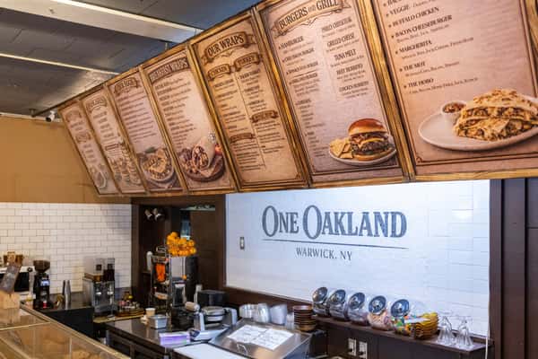 Restaurant counter with menu boards and open kitchen at One Oakland in Warwick, NY, casual American diner atmosphere