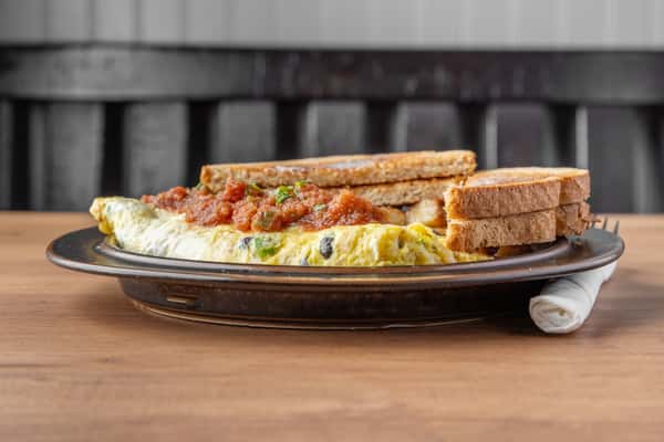 Vegetable omelet topped with salsa served with toast, classic American diner breakfast plate