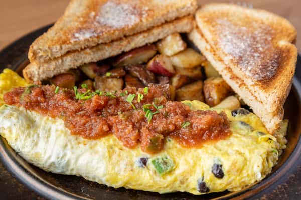 Vegetable omelet topped with salsa served with home fries and toast, classic American diner breakfast at One Oakland