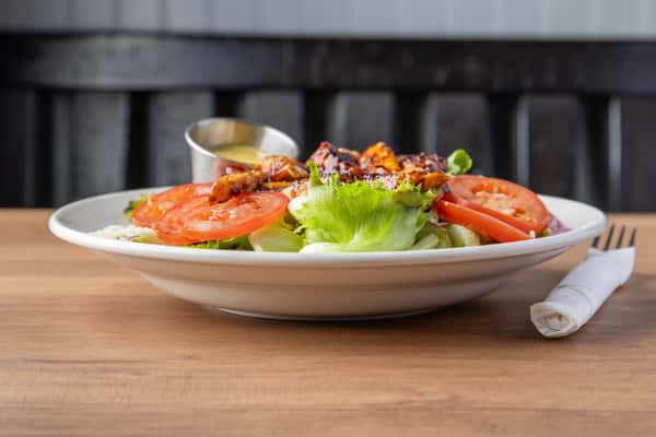 Grilled chicken salad with fresh lettuce, sliced tomatoes, and house dressing, light American lunch dish