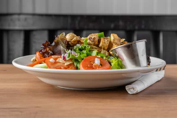 Grilled chicken salad with fresh greens, tomatoes, and house dressing, light and healthy lunch option