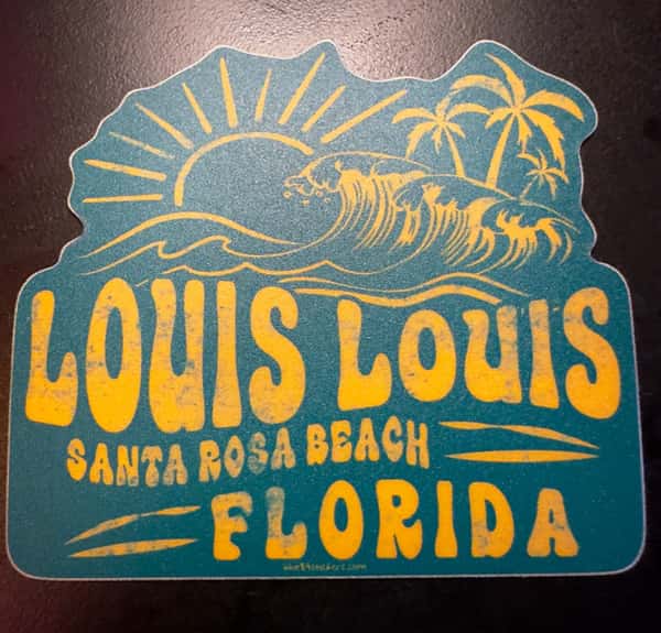 A vintage-style sticker with a wave, sun, and palm trees, reading "LOUIS LOUIS SANTA ROSA BEACH FLORIDA" in bold, yellow text.